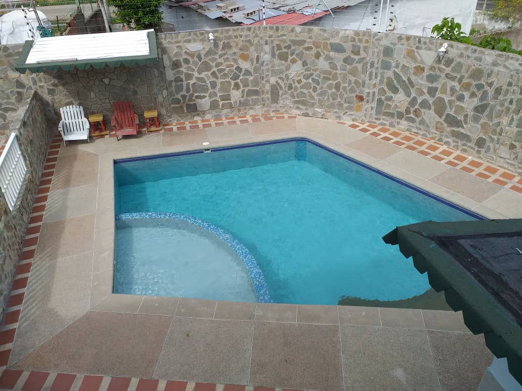 Piscina de forma irregular con sillas Adirondack